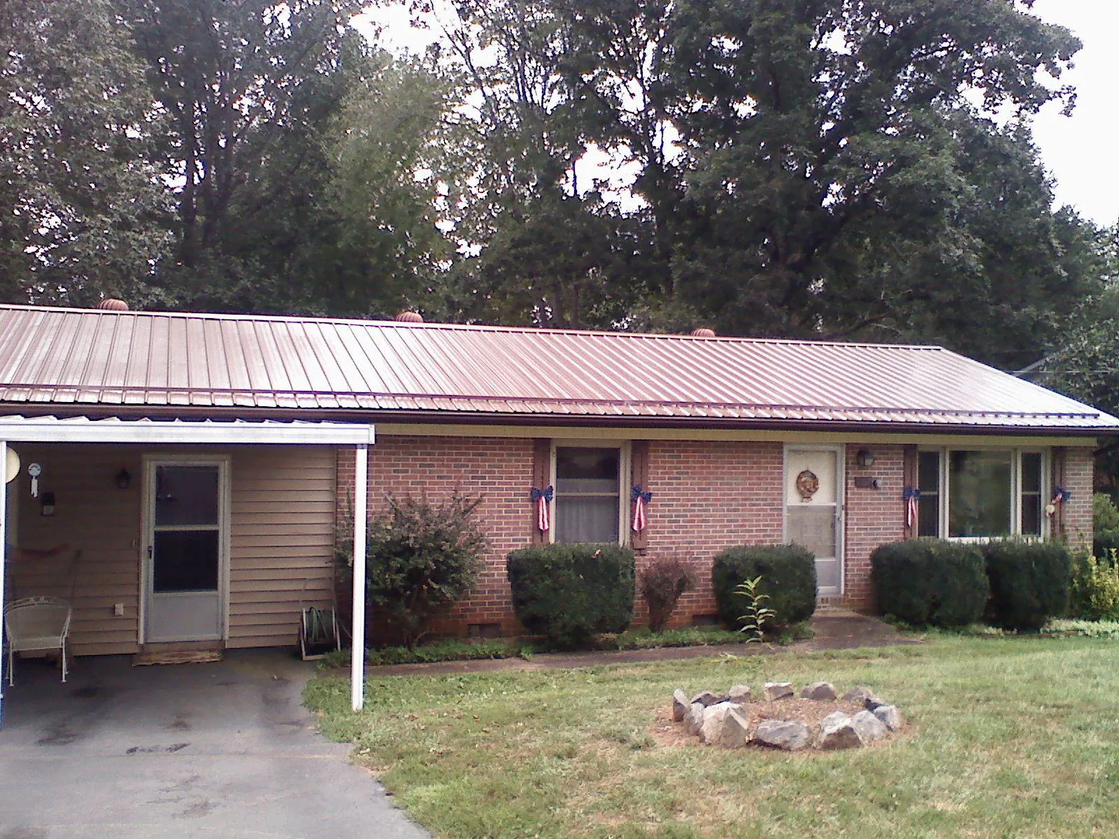 Bronze metal roof and carport on a brick ranch home — Roof Repair work by our crew in Dennis